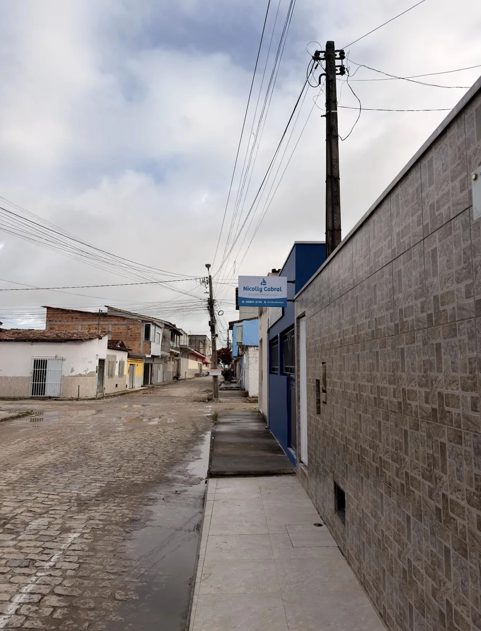 Vista da rua e da placa da clínica no bairro São Lourenço